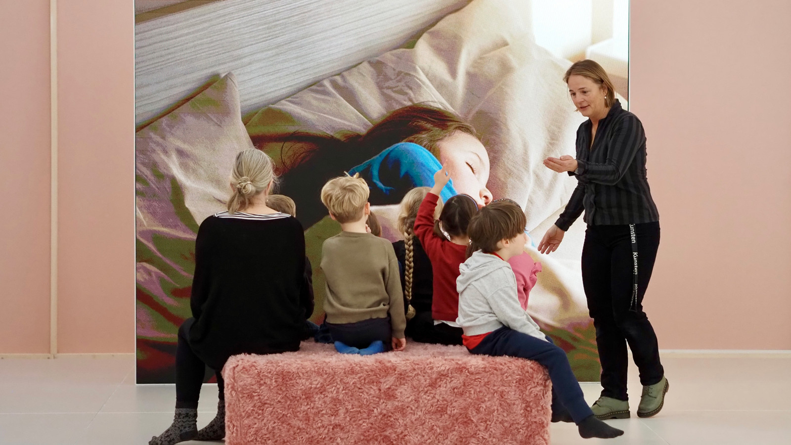 Børn der sidder foran et kunstværk